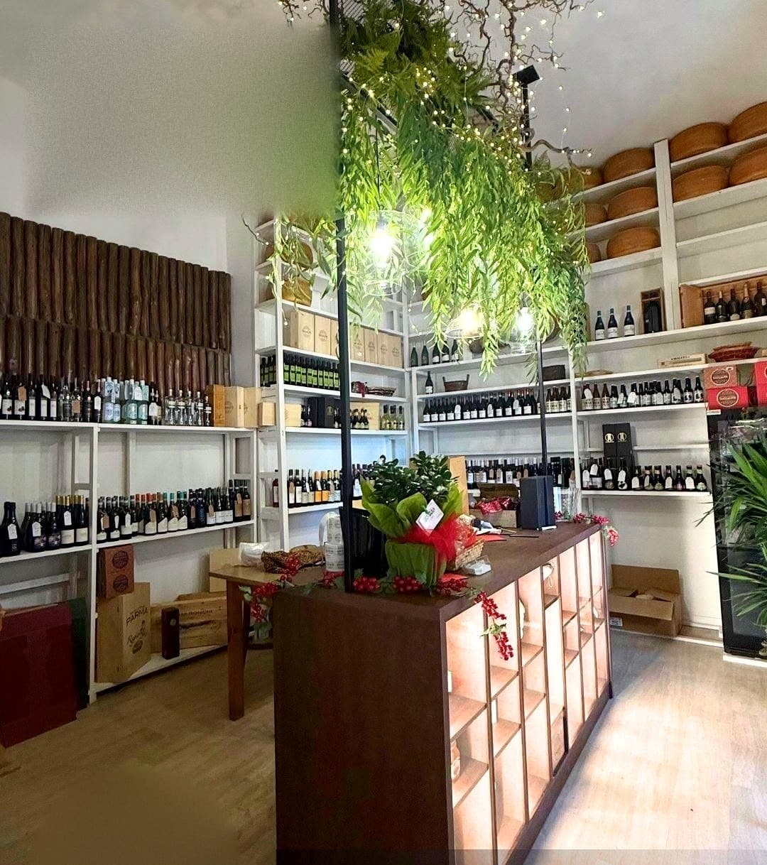 La sala dell'aperitivo in bottega, tra gli scaffali dei vini e le forme di formaggio