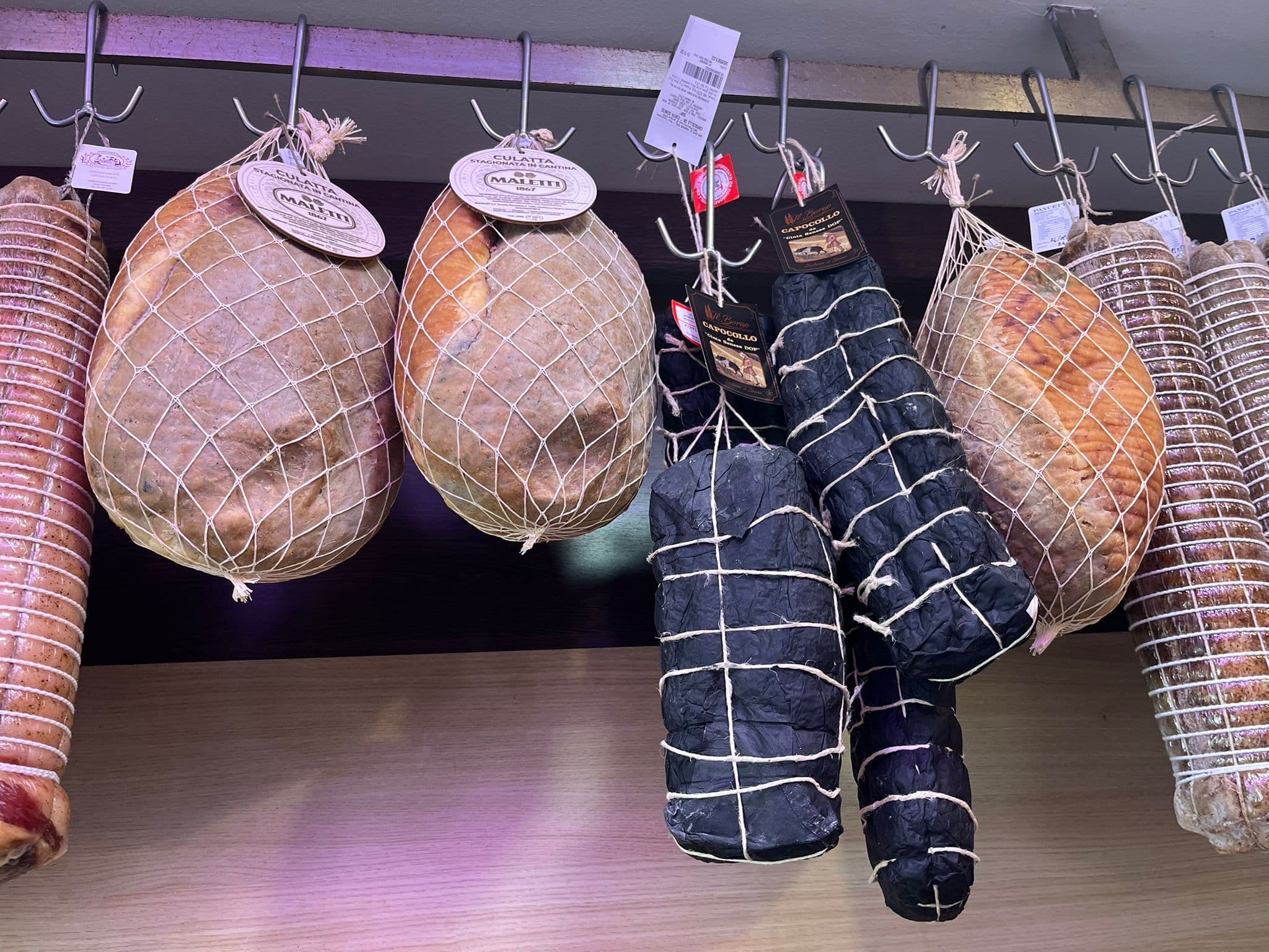 Salumi appesi in stagionatura al Mercato del Piano